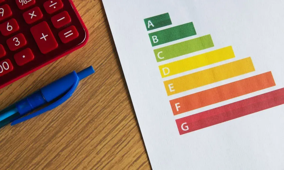Calculatrice rouge, stylo bleu et graphique DPE. Le gel des loyers pourrait impacter les logements classés E.