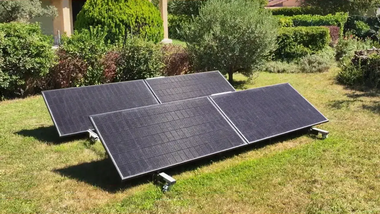 Panneaux solaires sur pelouse, promesse de rentabilité panneau solaire autoconsommation. Jardin verdoyant, maison en arrière-plan.