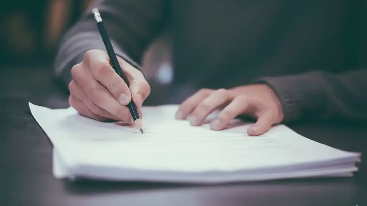 Main tenant rédige une demande d'autorisation pour une toiture en bac acier.