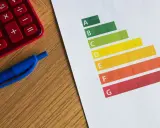 Calculatrice rouge, stylo bleu et graphique DPE. Le gel des loyers pourrait impacter les logements classés E.