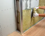 Pose d'isolant minéral pour comment insonoriser une chambre à coucher. Pose de laine de roche dans une structure métallique.