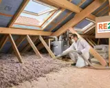 Pose de laine de verre 2 couches dans un grenier pour une isolation optimale, conforme à la RE2020.