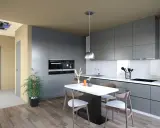 Cuisine moderne avec îlot central. Un système hygro A ou B est visible au plafond, assurant une ventilation optimale.