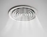 Grille de ventilation ronde au plafond, diffusant une légère brume. On dirait que la VMC pas assez puissante peine à renouveler l'air.