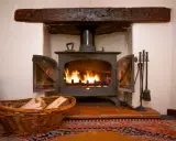Un insert cheminée moderne, idéal pour ma prime rénov, diffuse une douce chaleur. Un panier de bois à côté promet des soirées cosy.