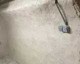 Mur brut avec prises électriques et tuyau, prêt pour enlever humidité maison. Un robinet bleu est visible à gauche.
