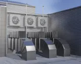 Système de ventilation extérieure avec plusieurs ventilateurs et conduits métalliques. Ce système pourrait être une VMC hygroréglable ou autoréglable pour un bâtiment.
