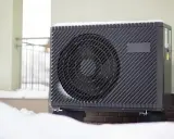 Unité extérieure de climatisation recouverte de neige, signe qu'elle givre.