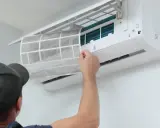 Un technicien nettoie le filtre d'une climatisation réversible. Un entretien régulier assure un air sain et optimise le tarif entretien clim réversible.