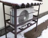 Unité extérieure de pompe à chaleur grand froid sous un abri enneigé. Avis sur sa performance en hiver.