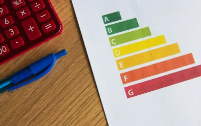 Calculatrice rouge, stylo bleu et graphique DPE. Le gel des loyers pourrait impacter les logements classés E.