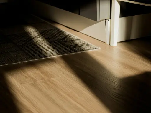 Rayons de soleil traversant un tapis sur un plancher de bois. L'isolation du plancher bois est discrète sous le tapis.