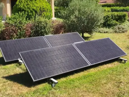 Panneaux solaires sur pelouse, promesse de rentabilité panneau solaire autoconsommation. Jardin verdoyant, maison en arrière-plan.