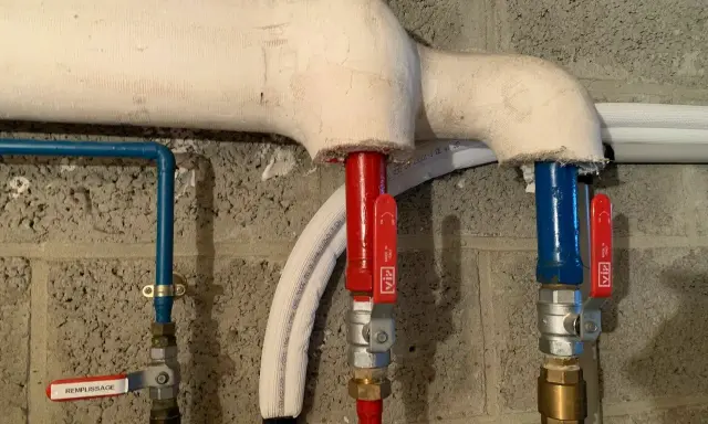Système de chauffage avec tuyaux isolés. Une vanne marquée "REMPLISSAGE" est visible.