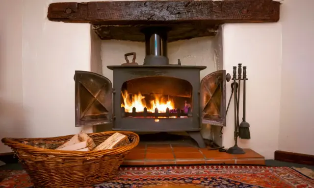 Un insert cheminée moderne, idéal pour ma prime rénov, diffuse une douce chaleur. Un panier de bois à côté promet des soirées cosy.