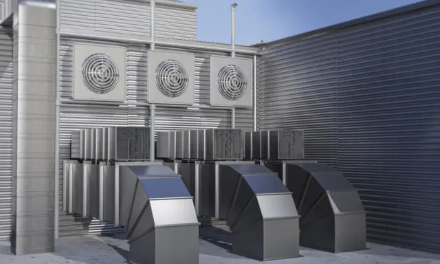 Système de ventilation extérieure avec plusieurs ventilateurs et conduits métalliques. Ce système pourrait être une VMC hygroréglable ou autoréglable pour un bâtiment.