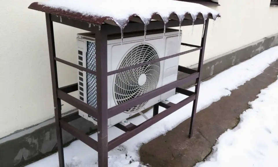 Unité extérieure de pompe à chaleur grand froid sous un abri enneigé. Avis sur sa performance en hiver.