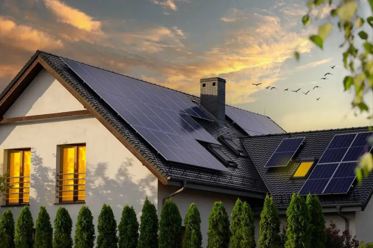 Maison avec installation panneau photovoltaique sur le toit, sous un ciel crépusculaire.