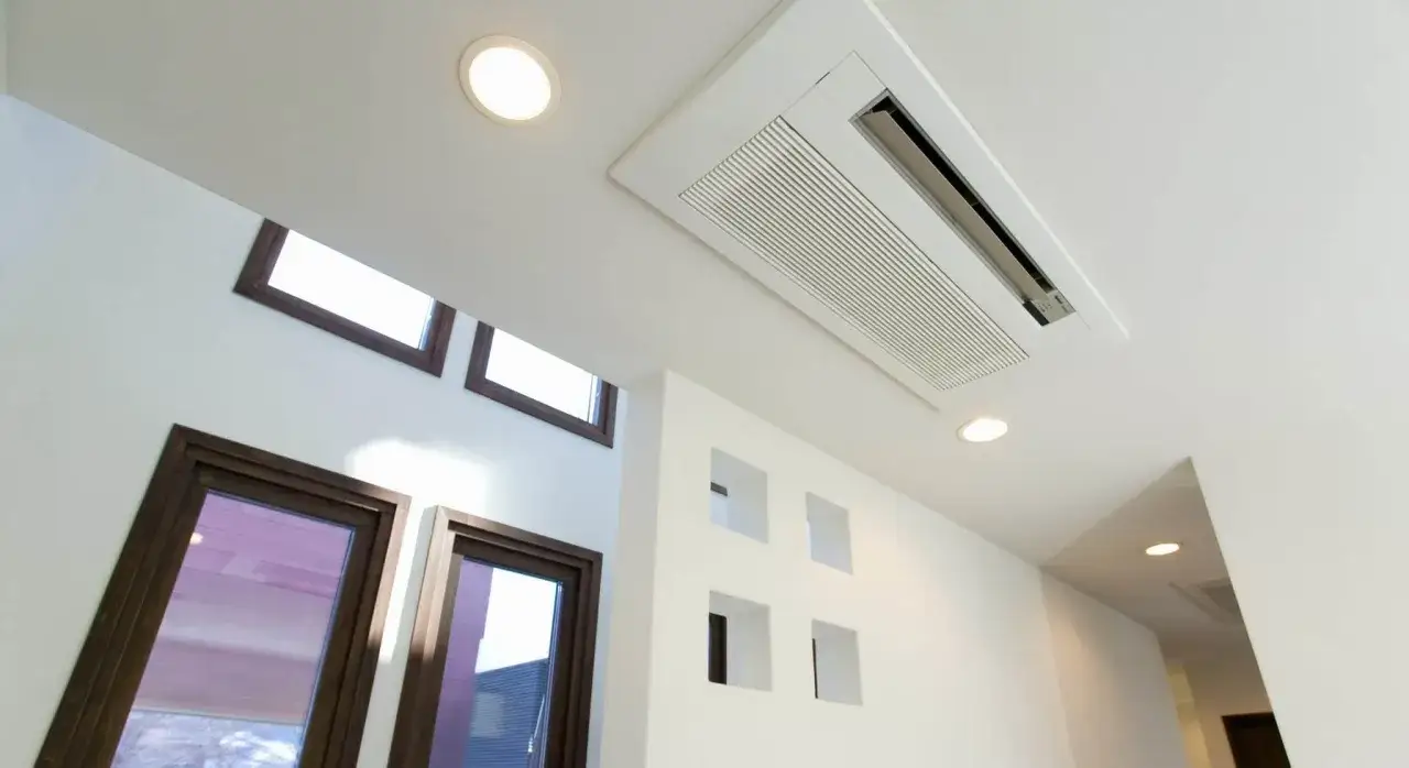 Unit&eacute; int&eacute;rieure de climatisation gainable discr&egrave;tement int&eacute;gr&eacute;e au plafond blanc, offrant un confort thermique optimal. Le prix d'un PAC air air gainable est un investissement judicieux.