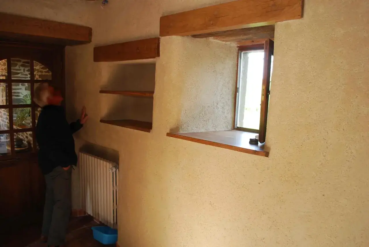 Murs en chaux chanvre, belle &eacute;paisseur pour une isolation naturelle. Une fen&ecirc;tre s'ouvre sur l'ext&eacute;rieur.